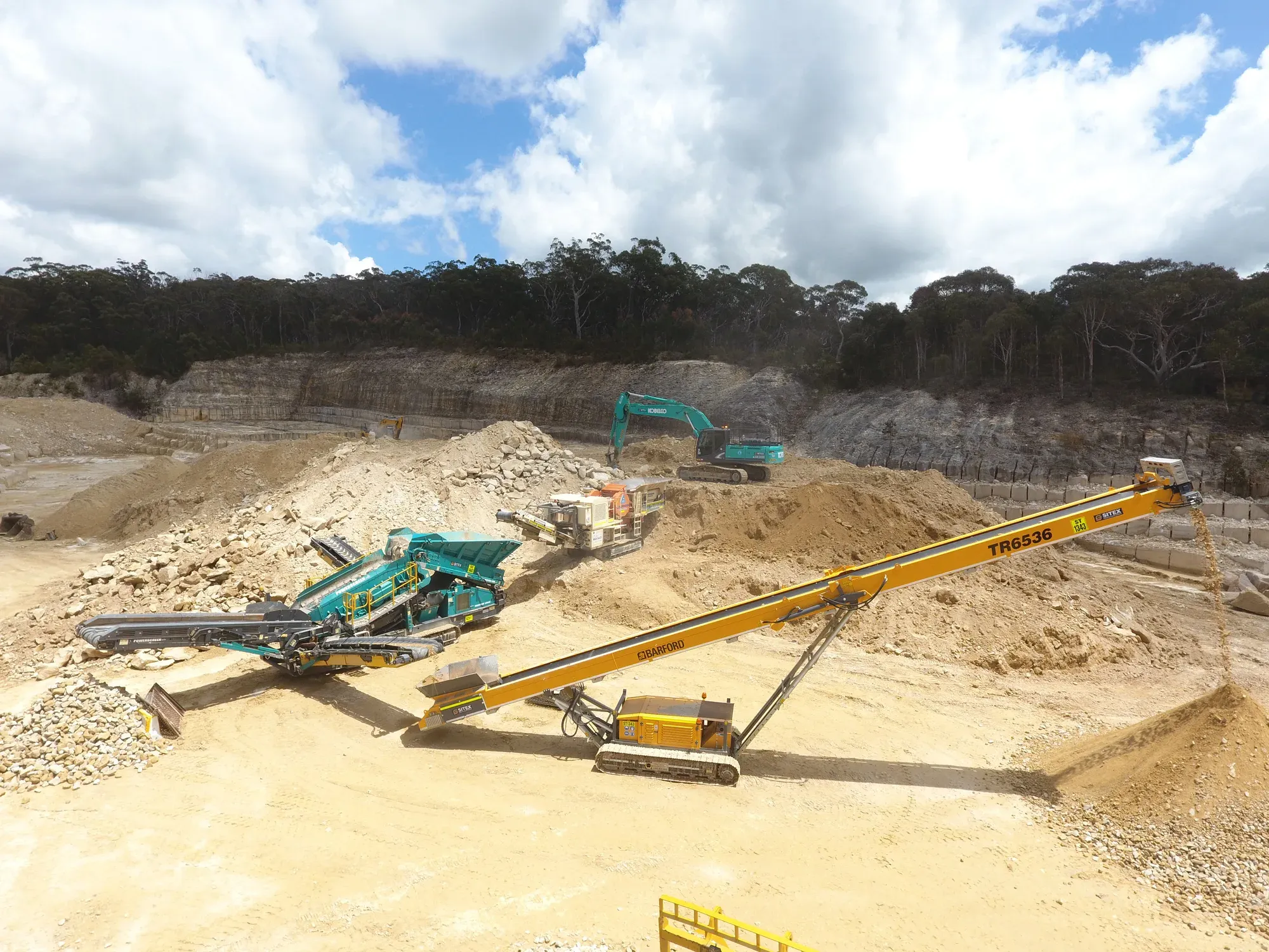 Aerial view of a screening and stacking train working a quarry floor