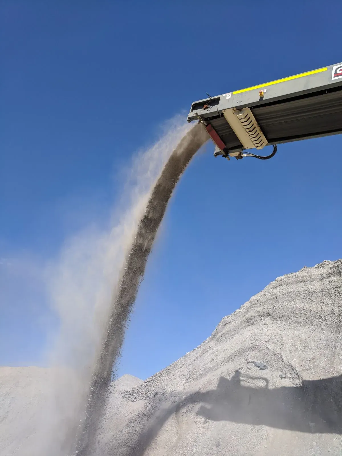 Graded material discharging from a tracked stockpiler